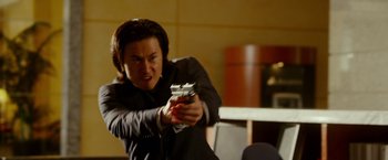 Movie still from “The Prince” (2014), directed by Brian A. Miller – A man holding a video game controller in his hand; Close Up shot, Over the shoulder angle