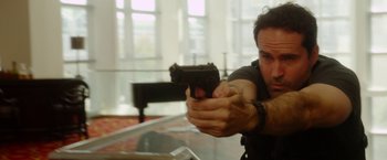 Movie still from “The Prince” (2014), directed by Brian A. Miller – A man holding a gun in his right hand; Close Up shot, Low angle
