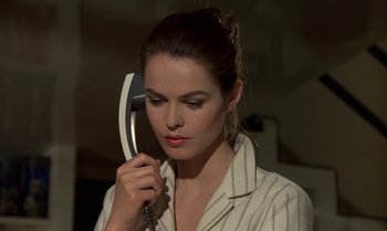 Movie still from “The Professional” (1981), directed by Georges Lautner – A beautiful woman holding a phone up to her face; Close Up shot, High angle