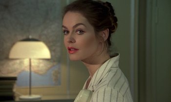 Movie still from “The Professional” (1981), directed by Georges Lautner – A beautiful woman with red lipstick wearing a white shirt; Close Up shot, Over the shoulder angle