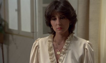 Movie still from “The Professional” (1981), directed by Georges Lautner – A person wearing a white shirt; Close Up shot, Over the shoulder angle