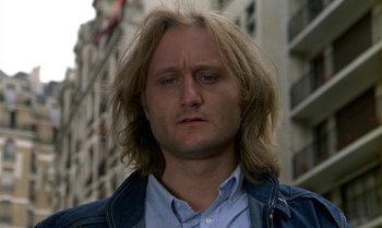 Movie still from “The Professional” (1981), directed by Georges Lautner – A person with long blonde hair; Close Up shot, Low angle