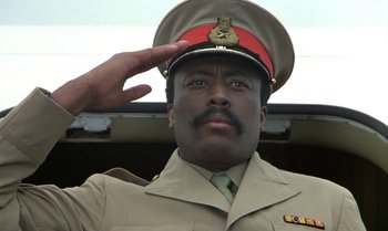 Movie still from “The Professional” (1981), directed by Georges Lautner – A man saluting while wearing an army uniform; Close Up shot, Low angle