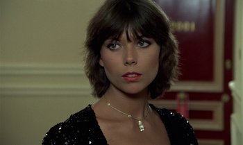 Movie still from “The Professional” (1981), directed by Georges Lautner – A person with short hair wearing a necklace; Close Up shot, Low angle
