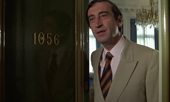 Movie still from “The Professional” (1981), directed by Georges Lautner – A person wearing a suit and tie; Close Up shot, Low angle