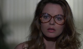 Movie still from “The Professional” (1981), directed by Georges Lautner – A person wearing glasses; Close Up shot, Over the shoulder angle