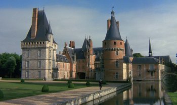 Movie still from “The Professional” (1981), directed by Georges Lautner – A man standing in front of an old castle; Extreme Wide shot, High angle