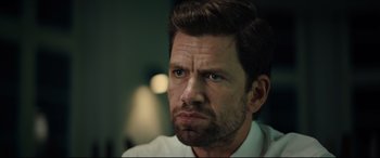 Movie still from “Journal 64” (2018), directed by Christoffer Boe – A person wearing a white shirt; Close Up shot, Over the shoulder angle