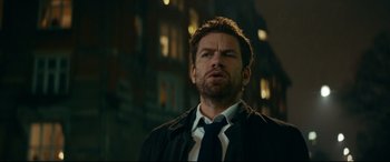 Movie still from “Journal 64” (2018), directed by Christoffer Boe – A person wearing a suit and tie; Close Up shot, Low angle