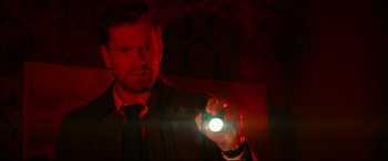 Movie still from “Journal 64” (2018), directed by Christoffer Boe – A man in a suit and tie holding a flashlight; Close Up shot, Low angle
