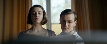 Movie still from “Journal 64” (2018), directed by Christoffer Boe – A man and a woman are reading a book together; Close Up shot, Low angle