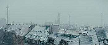 Movie still from “Journal 64” (2018), directed by Christoffer Boe – A view of a city skyline in the snow; Extreme Wide shot, Low angle