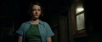 Movie still from “Journal 64” (2018), directed by Christoffer Boe – A woman in a green dress and a blue shirt; Close Up shot, Low angle