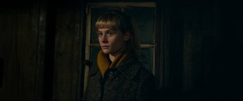 Movie still from “Journal 64” (2018), directed by Christoffer Boe – A young woman in front of a window wearing a coat; Close Up shot, Low angle