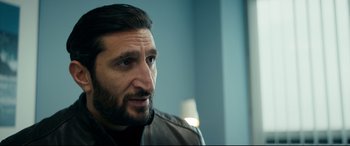 Movie still from “Journal 64” (2018), directed by Christoffer Boe – A person wearing a jacket; Close Up shot, Over the shoulder angle