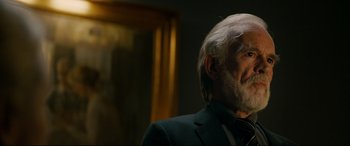 Movie still from “Journal 64” (2018), directed by Christoffer Boe – An old man with a beard and a suit; Close Up shot, Over the shoulder angle