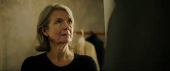 Movie still from “Journal 64” (2018), directed by Christoffer Boe – An older woman looking into a mirror in a dressing room; Close Up shot, Over the shoulder angle