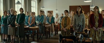 Movie still from “Journal 64” (2018), directed by Christoffer Boe – A group of people standing in a room; Wide shot, Over the shoulder angle