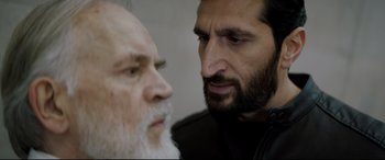 Movie still from “Journal 64” (2018), directed by Christoffer Boe – A man with a beard is looking at another man with a beard; Close Up shot, Over the shoulder angle
