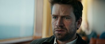 Movie still from “Journal 64” (2018), directed by Christoffer Boe – A person with a beard; Close Up shot, Over the shoulder angle