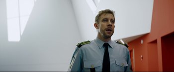 Movie still from “Journal 64” (2018), directed by Christoffer Boe – A person wearing a uniform; Close Up shot, Low angle