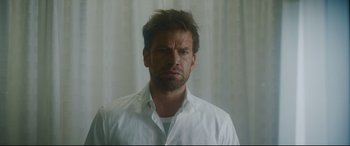 Movie still from “Journal 64” (2018), directed by Christoffer Boe – A person wearing a white shirt; Close Up shot, Low angle