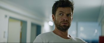 Movie still from “Journal 64” (2018), directed by Christoffer Boe – A person wearing a white t - shirt; Close Up shot, Low angle