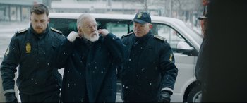 Movie still from “Journal 64” (2018), directed by Christoffer Boe – Two men standing next to each other on a snowy day; Medium shot, Over the shoulder angle