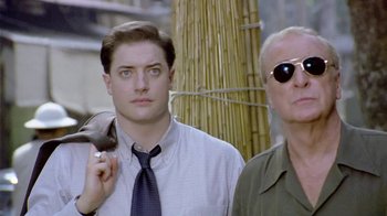 Movie still from “The Quiet American” (2002), directed by Phillip Noyce – A man and a woman standing next to each other in front of bamboo; Close Up shot, Low angle