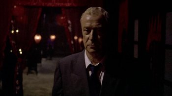 Movie still from “The Quiet American” (2002), directed by Phillip Noyce – A man wearing a suit and tie standing in the dark; Close Up shot, Low angle