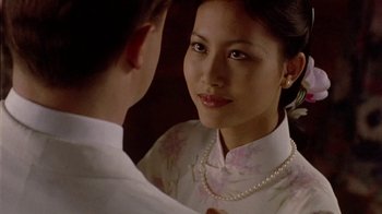 Movie still from “The Quiet American” (2002), directed by Phillip Noyce – A young woman wearing a pearl necklace looking into a mirror; Close Up shot, Over the shoulder angle