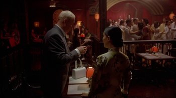 Movie still from “The Quiet American” (2002), directed by Phillip Noyce – An older man in a suit and a woman in an oriental dress; Medium shot, Over the shoulder angle