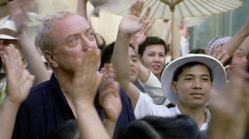 Movie still from “The Quiet American” (2002), directed by Phillip Noyce – A group of people sitting in front of each other; Close Up shot, Over the shoulder angle