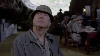 Movie still from “The Quiet American” (2002), directed by Phillip Noyce – An older man wearing a hat looking up at the sky; Close Up shot, Low angle