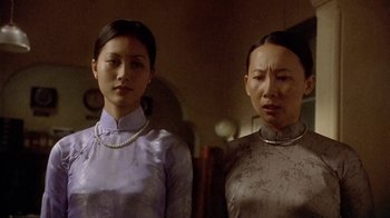 Movie still from “The Quiet American” (2002), directed by Phillip Noyce – Two asian women standing next to each other; Close Up shot, Low angle