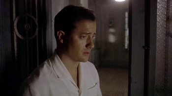 Movie still from “The Quiet American” (2002), directed by Phillip Noyce – A man in a white shirt is standing in a room; Close Up shot, Low angle