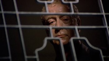 Movie still from “The Quiet American” (2002), directed by Phillip Noyce – A person behind a metal fence; Close Up shot, Low angle