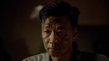 Movie still from “The Quiet American” (2002), directed by Phillip Noyce – A person wearing a gray shirt; Close Up shot, Low angle