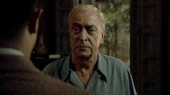 Movie still from “The Quiet American” (2002), directed by Phillip Noyce – An older man looking at the camera in front of a mirror; Close Up shot, Over the shoulder angle