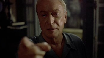 Movie still from “The Quiet American” (2002), directed by Phillip Noyce – An older man is looking at the camera; Close Up shot, Over the shoulder angle