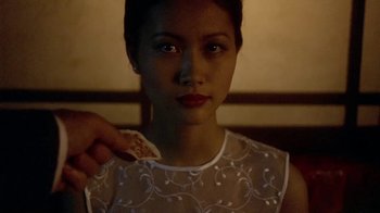 Movie still from “The Quiet American” (2002), directed by Phillip Noyce – A woman holding a slice of pizza in her hand; Close Up shot, Over the shoulder angle