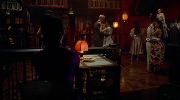 Movie still from “The Quiet American” (2002), directed by Phillip Noyce – A group of people dancing in a room with lights; Wide shot, High angle