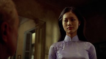 Movie still from “The Quiet American” (2002), directed by Phillip Noyce – A woman in a purple dress standing next to a window; Close Up shot, Low angle