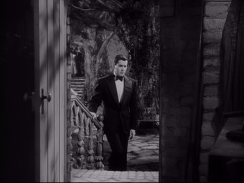 Movie still from “The Razor's Edge” (1946), directed by Edmund Goulding – A black and white photo of a man in a tuxedo; Wide shot, High angle