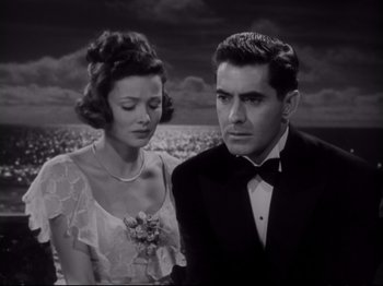 Movie still from “The Razor's Edge” (1946), directed by Edmund Goulding – A man and a woman standing next to each other in front of the ocean; Medium shot, High angle