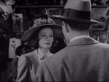Movie still from “The Razor's Edge” (1946), directed by Edmund Goulding – A woman wearing a hat talking to a man in a suit; Close Up shot, Over the shoulder angle