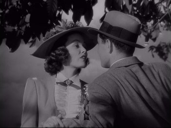 Movie still from “The Razor's Edge” (1946), directed by Edmund Goulding – A man and a woman in hats kissing; Medium shot, High angle