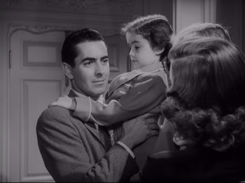 Movie still from “The Razor's Edge” (1946), directed by Edmund Goulding – A man and a woman holding a little girl in his arms; Medium shot, Low angle