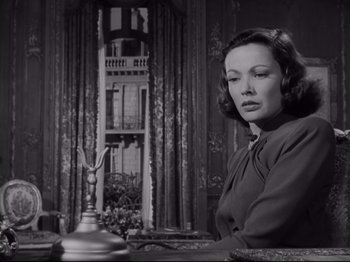 Movie still from “The Razor's Edge” (1946), directed by Edmund Goulding – A black and white photo of a woman sitting at a table; Medium shot, Low angle