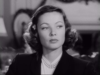 Movie still from “The Razor's Edge” (1946), directed by Edmund Goulding – A black - and - white photo of a woman in a suit and pearl necklace; Close Up shot, Low angle
